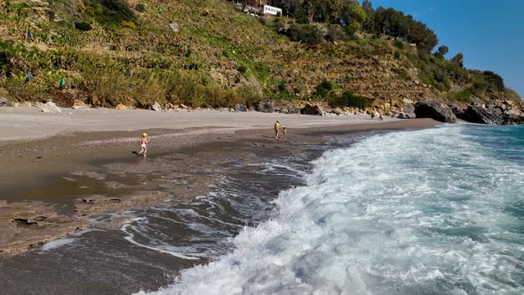 Happy children run on the waves aerial view 4 K