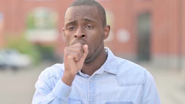 Outdoor Portrait of Sick Young African Man Coughing