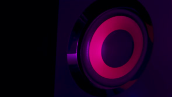 Macro Close Up of Black Vibrating Membranes Loud Sound Speaker in Colorful Neon Lighting