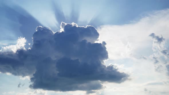 Building of a Large White Cloud in the Blue Sky, the Sun's Rays Shine Through the Cloud