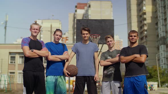 Smiling Streetball Players with Basketball on Court