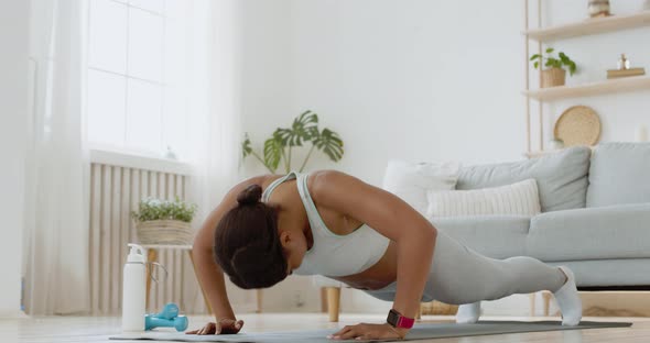 Young African American Woman Trying To Do Push Ups, Lying Down and Laughing