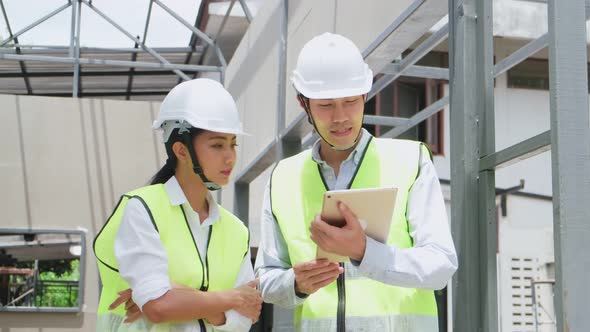 Asian colleague workers people wearing protective safety helmet, working on construction side.