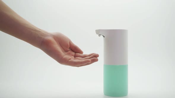 Close-up of a Teenager's Hand and Automatic Dispenser, Sanitizer on an Isolated Background, Close-up