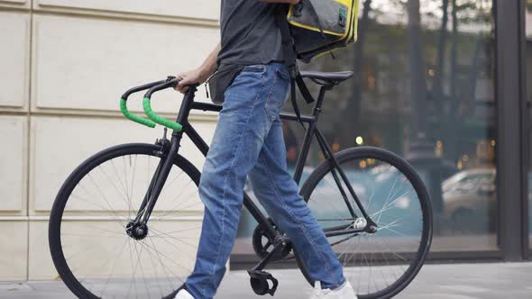 Delivery Man Who is Going and Texting on the Smartphone Searching for the Route