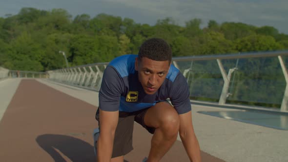 Determined Sporty Fit African Male Runner in Start Position Ready to Run