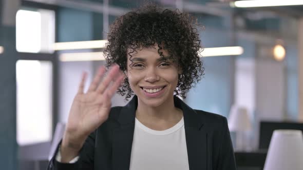 Portrait of Cheerful African Businesswoman Waving at Camera in Office