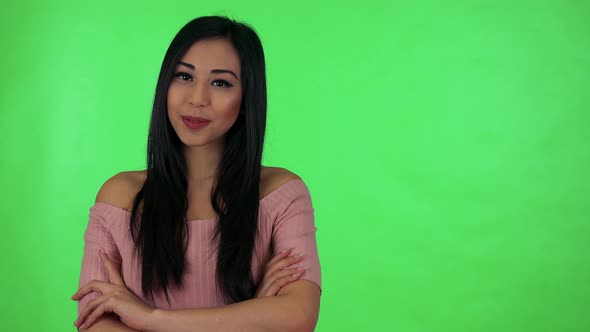 Young Attractive Asian Woman Smiles To Camera with Folded Arms - Green Screen Studio