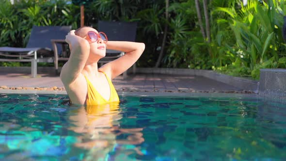 Young asian woman enjoy around outdoor swimming pool for leisure