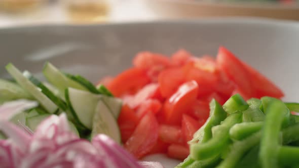 Camera follows putting diced feta cheese over salad. Slow Motion.