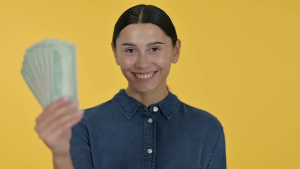 Latin Woman Holding Dollars, Yellow Background 