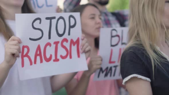 Side View of Activists Crowd with Anti-racism Banners Shouting. Group of Protesters Fighting Against