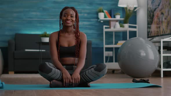 Portrait of Black Athlete Sitting in Lotus Position on Floor Enjoying Morning Workout