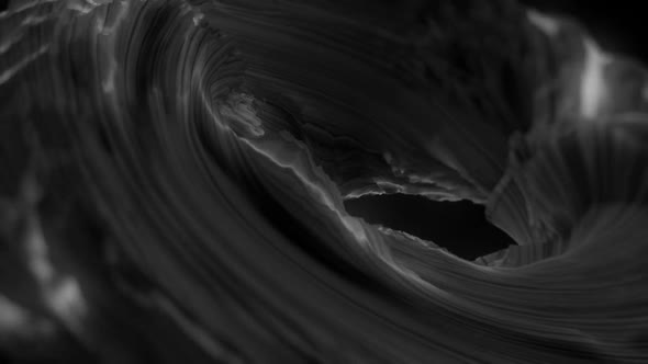 Grey vibrant glowing abstract shape flowing against black background