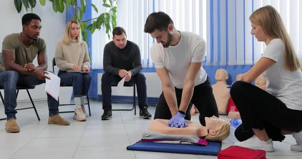 Instructor Demonstrating CPR on Mannequin at First Aid Training Course
