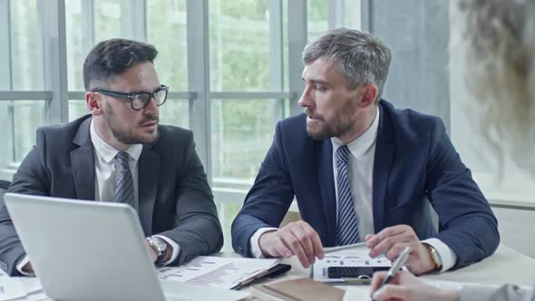 Businessmen with Laptop Discussing Work