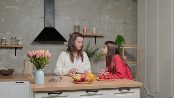 Mother Talks to Her Daughter While She Prepares the Vegetable Salad