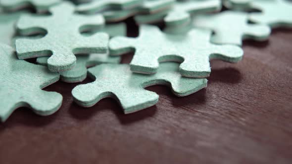 Jigsaw puzzle pieces on wooden background. Disconnected mixed game elements