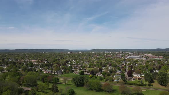 Panoramic view of city in valley in Wisconsin, brilliant blue sky, wispy clouds, mountains, forest. alt