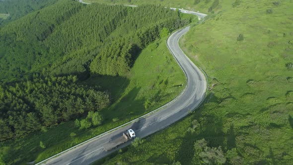 Empty Wood Transportation Truck Drving on Curvy Forest Mountain Road