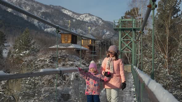 Child with Mother Walking on Suspension Bridge