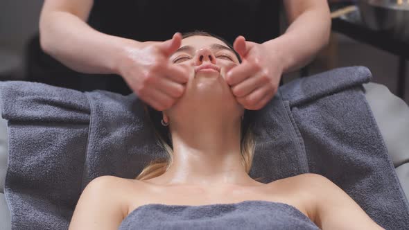 Caucasian Attractive Woman in the Spa Center Gets a Facelift, She Lies on the Bed and Relaxes