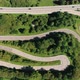 Aerial View Top Down of Racing Cars Ferrari and Jaguar Driving a Serpentine Mountain Road in Swiss - VideoHive Item for Sale
