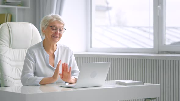 Smiling old woman manager with short grey hair talks