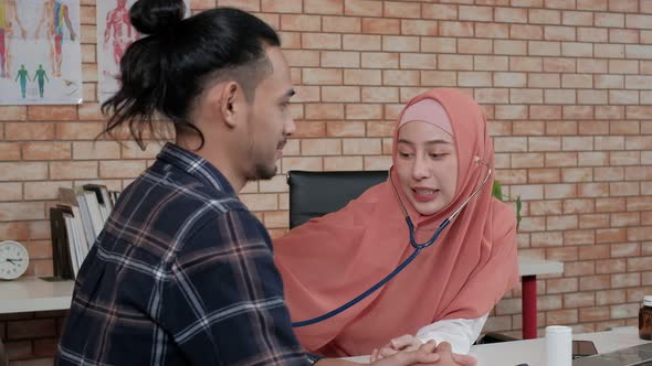  Young beautiful woman doctor is health examining a male patient.