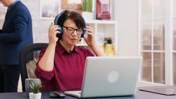 Old Woman Enjoying a Cup of Coffee While Working on Laptop