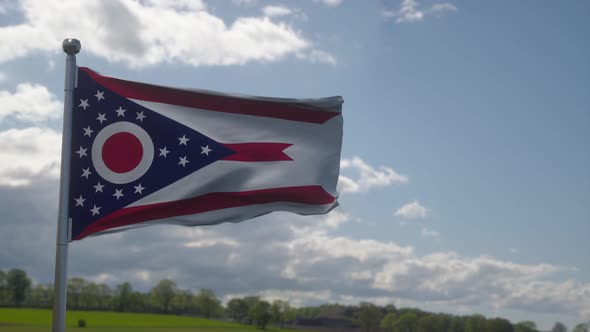 Ohio Flag on a Flagpole Waving in the Wind Blue Sky Background