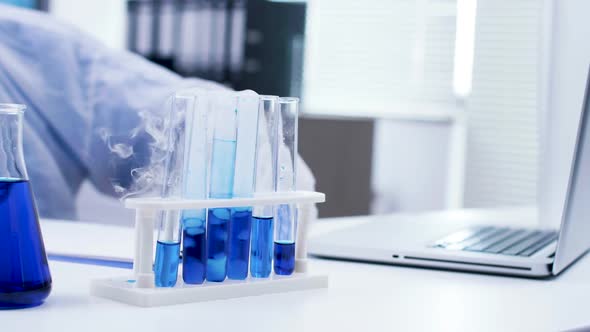 Close Up of Blue Fluid in Test Tubes Making Smoke