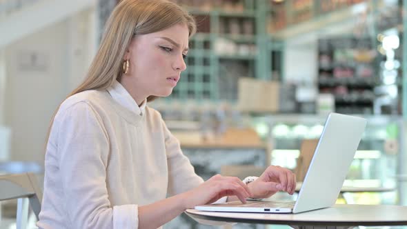 Shocked Expression By Young Woman Using Laptop in Cafe 