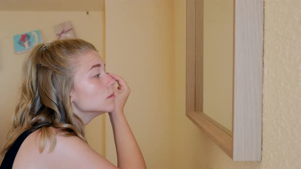 Young woman with eyebrow pencil applying makeup