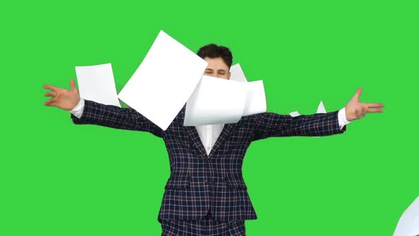 Businessman Throws Up Documents and Dances Happy on a Green Screen, Chroma Key.