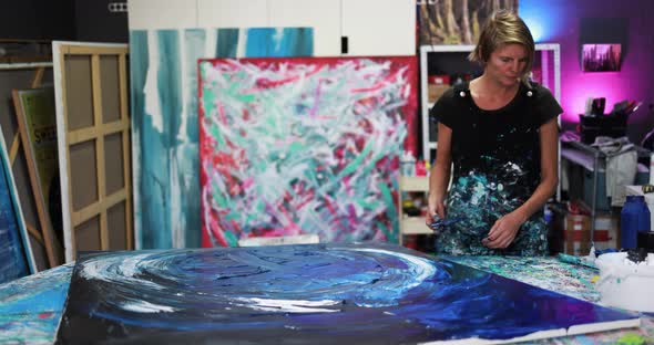 Mature woman painting inside her atelier studio at home