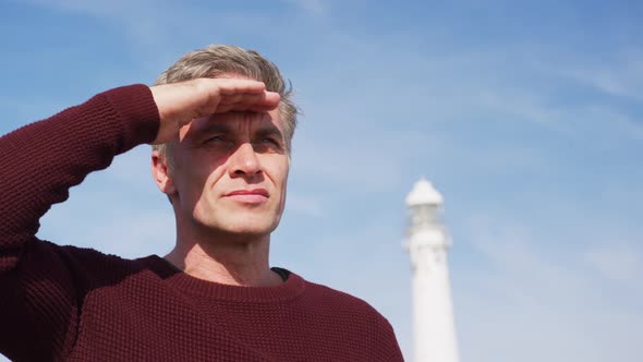 Caucasian man enjoying free time by sea on sunny day looking away 