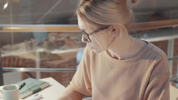 Female Fashion Designer Working with Illustrations at Desk