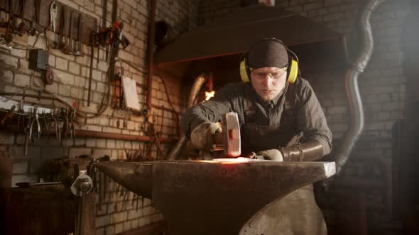 A Man Blacksmith Making a Knife with a Hammer - Looking for Imperfections