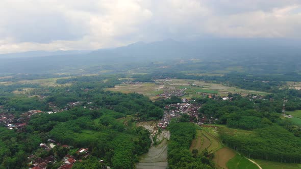 Grabag village with mountains shrouded in clouds Indonesia. Aerial forward