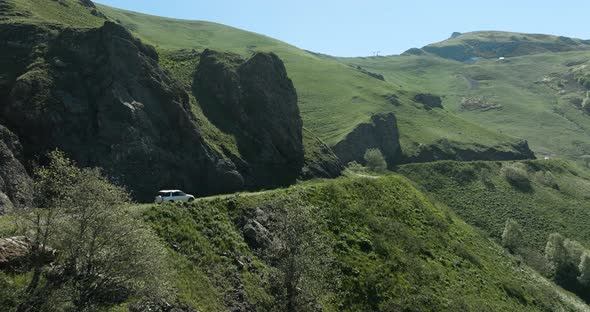 AERIAL - Car driving in dangerous Tskhratskaro Pass, Georgia, forward slow motion