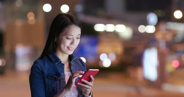 Woman look at smart phone in city at night