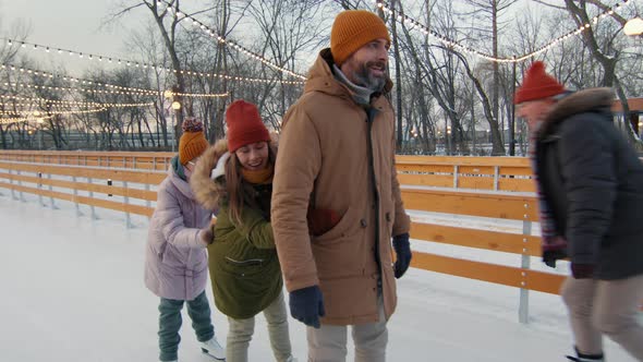 Cheerful Family Having Fun At Ice Rink