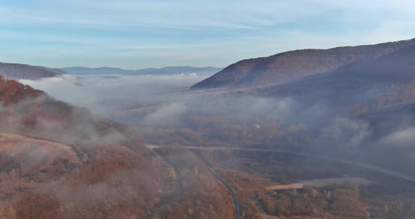 Aerial View From Above of a Morning Fog Over Mountain Valley Landscape with Autumn Forest