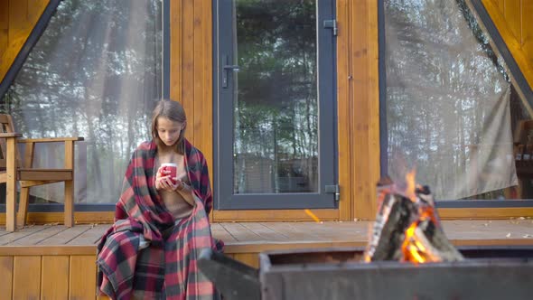 Beautiful Girl Wrapped in a Blanket at Autumn Warm Day