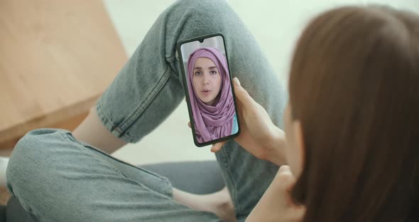 Female Using Medical App on Smartphone Consulting with Arab Muslim Woman in Hijab Doctor Via Video