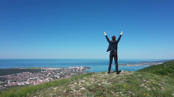 Businessman on Top of Mountain. Concept of Success
