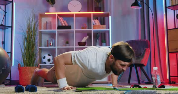 Bearded Guy Doing Push-Ups from the Floor During Home Training in the Evening