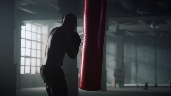 Athlete Hitting Punching Bag in Gloves