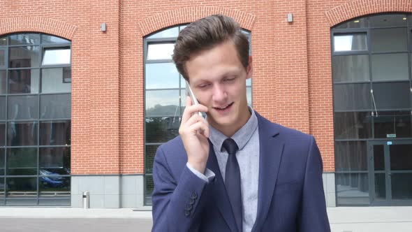 Happy Walking Young Businessman Talking on Phone, Outdoor